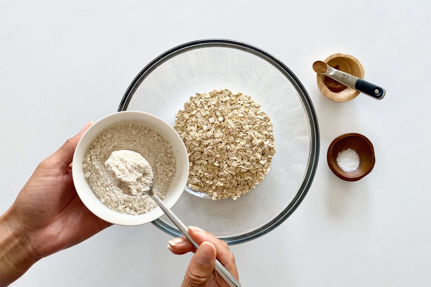 Making Chewy Fruit and Nut Granola Bars by mixing the dry ingredients in a glass bowl.